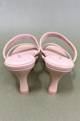 Pair of pink high-heeled shoes on a gray background