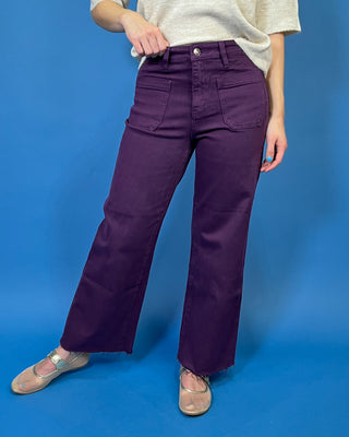 Deep purple high-rise wide leg jeans with front patch pockets, a flattering structured fit, and trendy raw hem detailing.