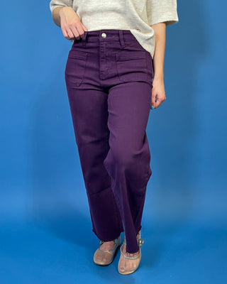 Deep purple high-rise wide leg jeans with front patch pockets, a flattering structured fit, and trendy raw hem detailing.