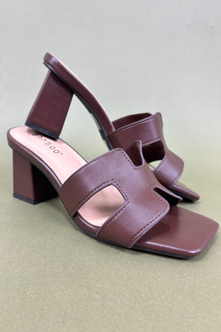 Brown sandal with a block heel on a light gray background