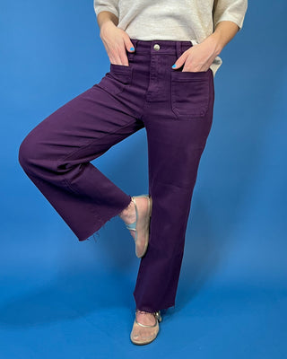 Deep purple high-rise wide leg jeans with front patch pockets, a flattering structured fit, and trendy raw hem detailing.