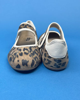 A pair of Mary Jane shoes with a brown and black leopard print pattern and white stripes, displayed on a solid blue background.
