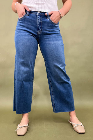 Person wearing blue jeans on a green background