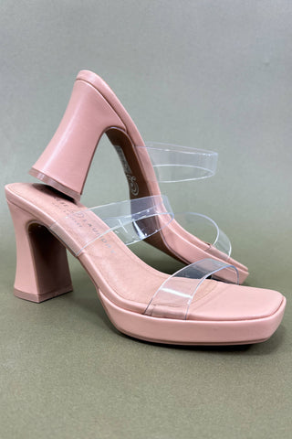 Pink high-heeled shoes with clear straps on a gray background