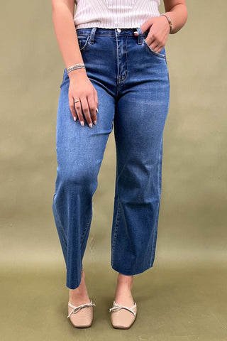 Person wearing blue jeans on a plain background