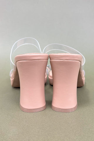 Pair of pink high-heeled shoes on a light gray background