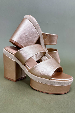 Beige platform sandals on a green background