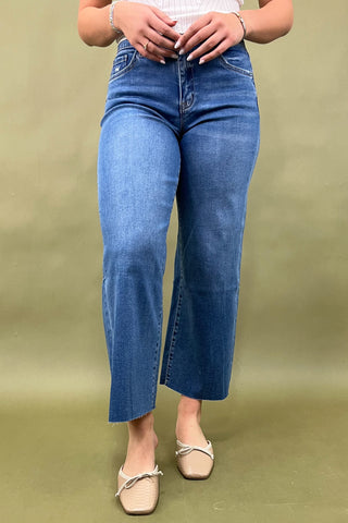 Person wearing blue jeans on a green background
