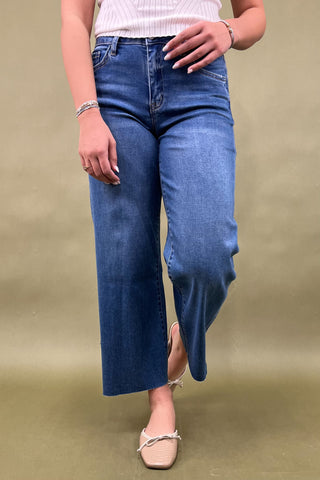 Person wearing blue jeans on a beige background