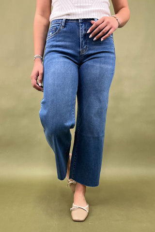 Person wearing blue jeans on a plain background