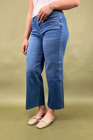 Person wearing blue jeans on a green background