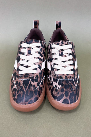 Pair of leopard print sneakers with white laces on a light green background