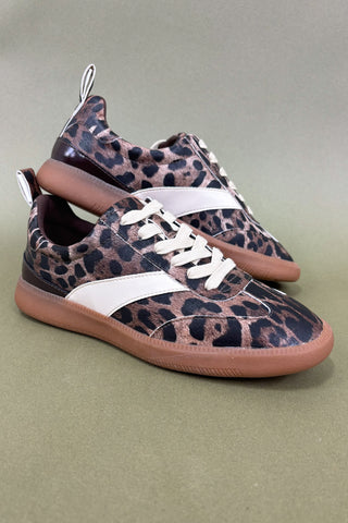 Leopard print sneakers with white laces on a green background