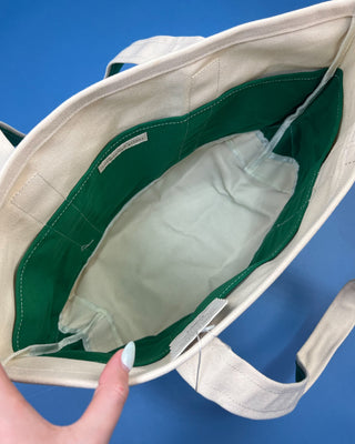 Large heavyweight canvas tote bag with contrast trim, reinforced shoulder straps, exterior slip pocket, and spacious interior available in multiple colors.
