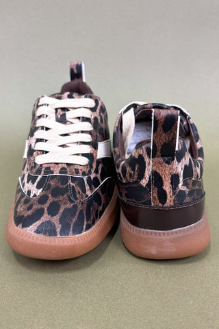 Pair of leopard print sneakers on a light green background