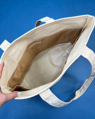 Large heavyweight canvas tote bag with contrast trim, reinforced shoulder straps, exterior slip pocket, and spacious interior available in multiple colors.