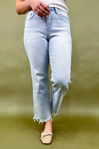 Light blue jeans worn by a person on a green background