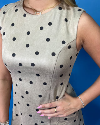 Taupe sleeveless mini dress with black polka dots, round neckline, and flattering A-line silhouette.