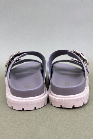 Pair of gray sandals with white soles on a gray background