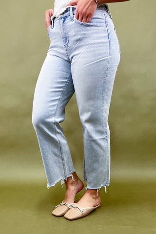 Light blue jeans worn by a person on a green background