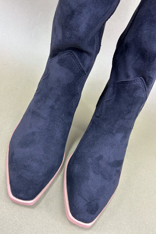 Pair of blue suede boots on a light gray background