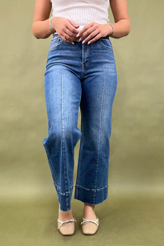 Person wearing blue jeans on a green background