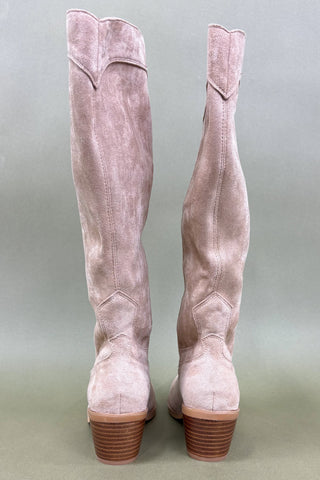 Pair of pink suede knee-high boots on a light gray background