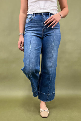 Person wearing blue jeans on a green background