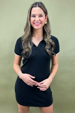 Woman wearing a black dress against a green background