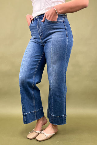 Person wearing blue jeans on a green background