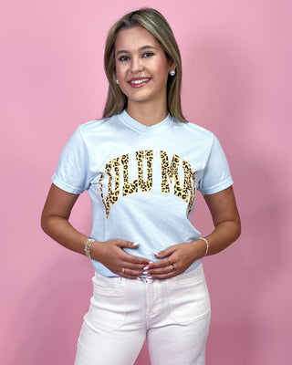 Woman wearing a white t-shirt with gold leopard print design on a pink background