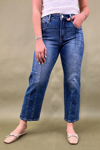 Person wearing blue jeans on a beige background