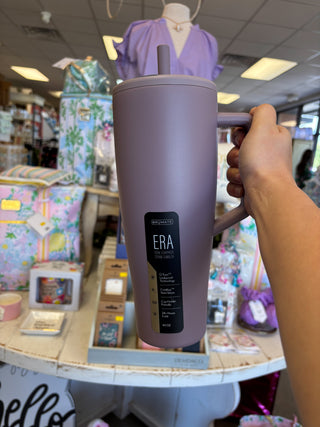 Person holding a purple tumbler with 'ERA' branding in a store setting