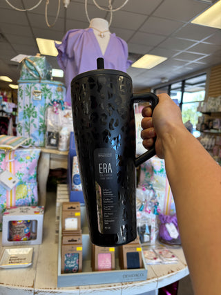 Person holding a black mug with 'ERA' branding in a store setting