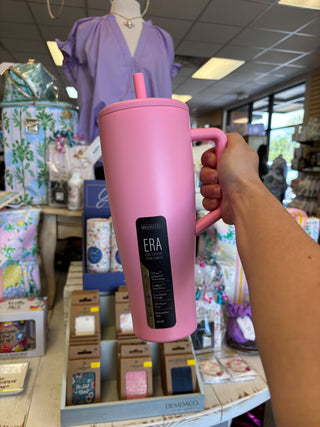 Pink tumbler with 'ERA' branding held by a person in a store setting.