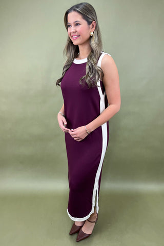 Woman wearing a purple dress with a white stripe on a green background