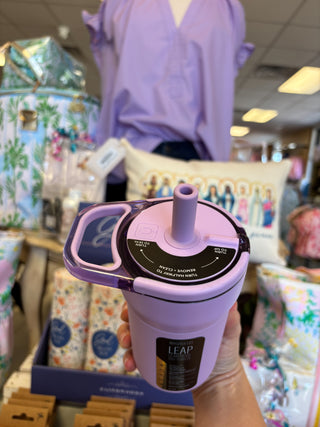 Purple and black device with a handle, branded 'LEAP', held in a store setting.