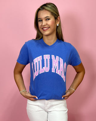 Woman wearing a blue t-shirt with pink text on a pink background