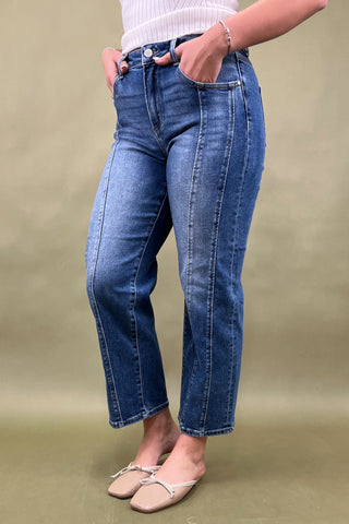Person wearing blue jeans on a beige background