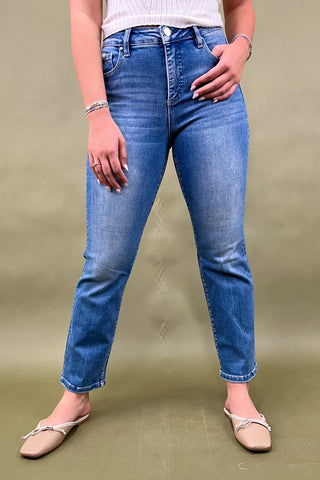 Person wearing blue jeans on a plain background
