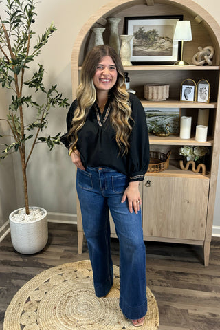 Woman standing in a room with wooden shelves and decor
