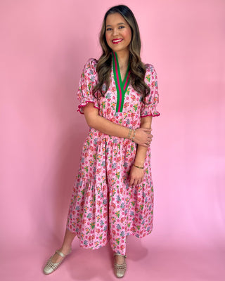 Woman wearing a pink floral dress against a pink background