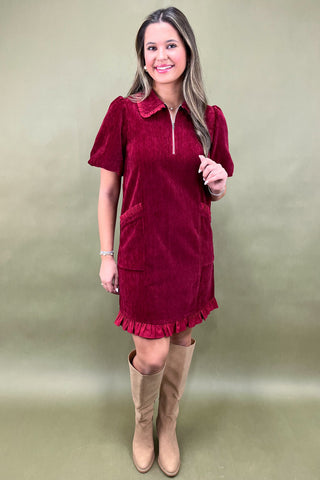 Woman wearing a red dress with a plain background