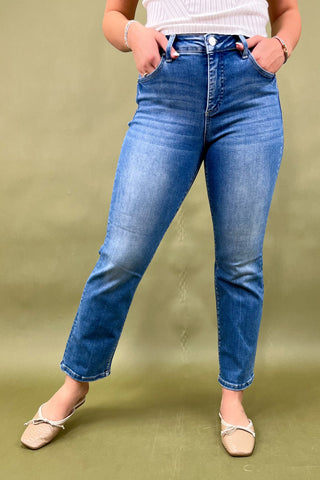 Person wearing blue jeans on a green background