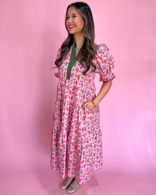 Woman wearing a pink floral dress against a pink background