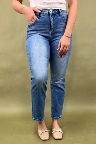 Person wearing blue jeans on a green background