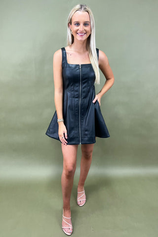 Woman wearing a black dress against a green background