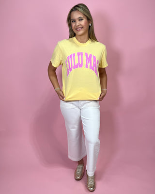 Woman wearing a yellow t-shirt with pink text on a pink background