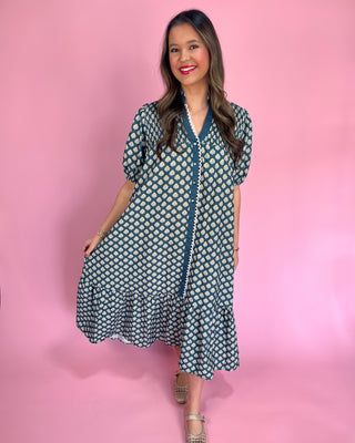 Woman wearing a patterned dress against a pink background