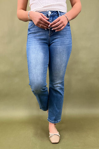 Person wearing blue jeans on a green background